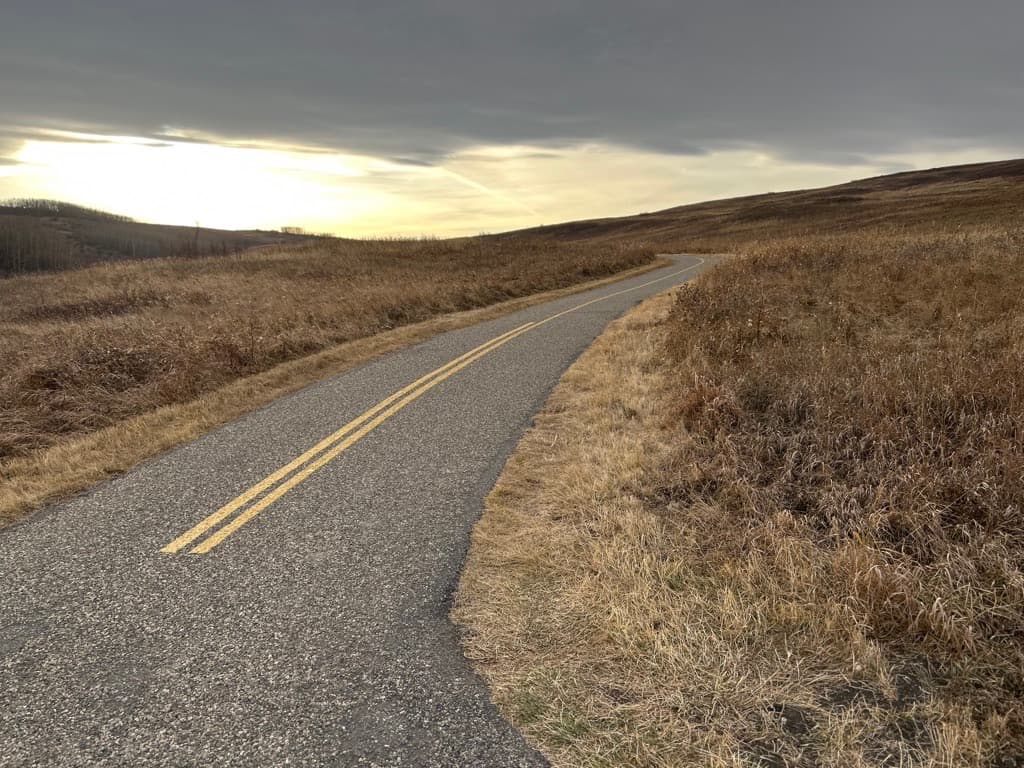 A quiet mountain lake after weather — the body's return to steadiness after what's been carried
