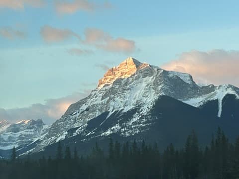 Snow-capped mountain peak bathed in golden sunset light
